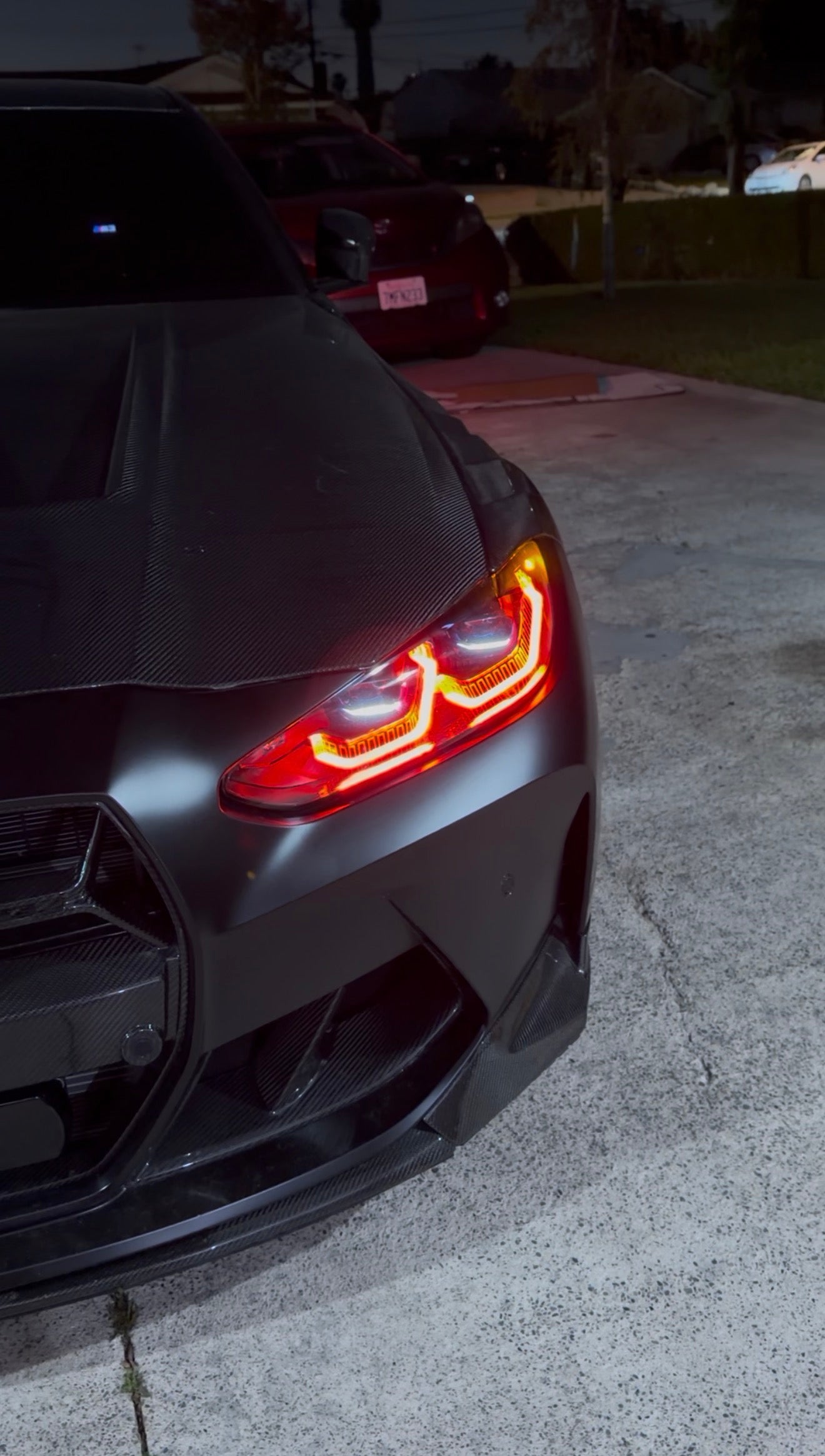 BMW G80 M3 and G82 M4 equipped with red LED daytime running lights using a vehicle-specific Red DRL Module Kit for a motorsport-inspired appearance.