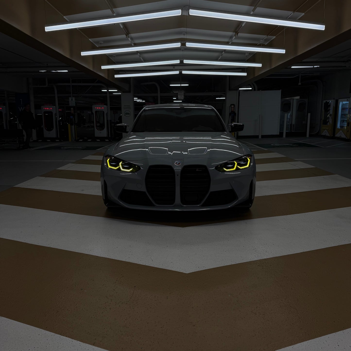 Car with glowing headlights in a dark garage