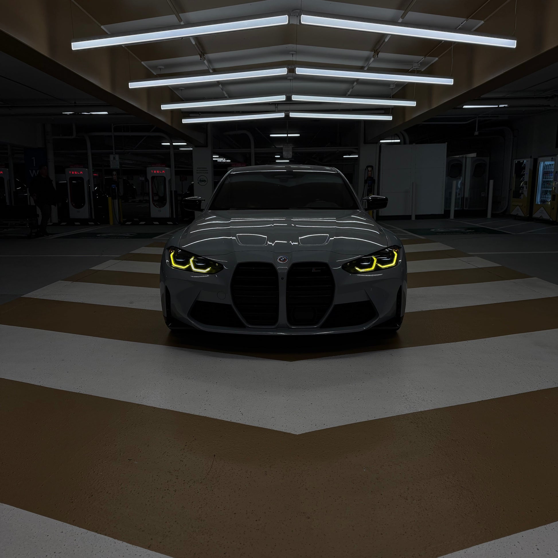 Car with glowing headlights in a dark garage